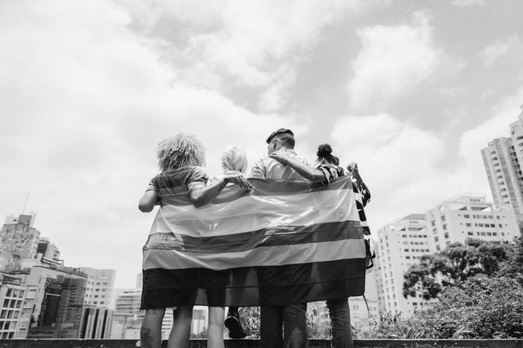 people posing with a pride flag outside